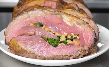 Whole Stuffed strip loin with sautéed apple, spinach, bleu cheese, and pine nuts