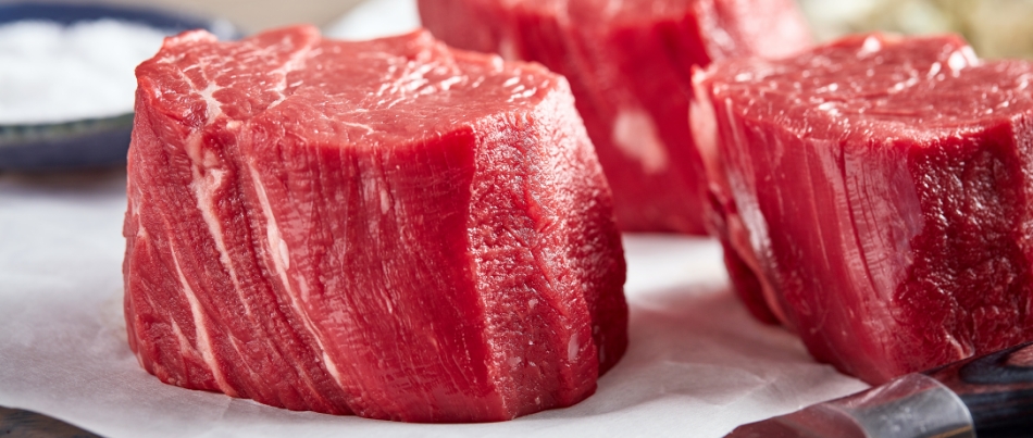 Three raw, thick, bright red beef tenderloin steaks 